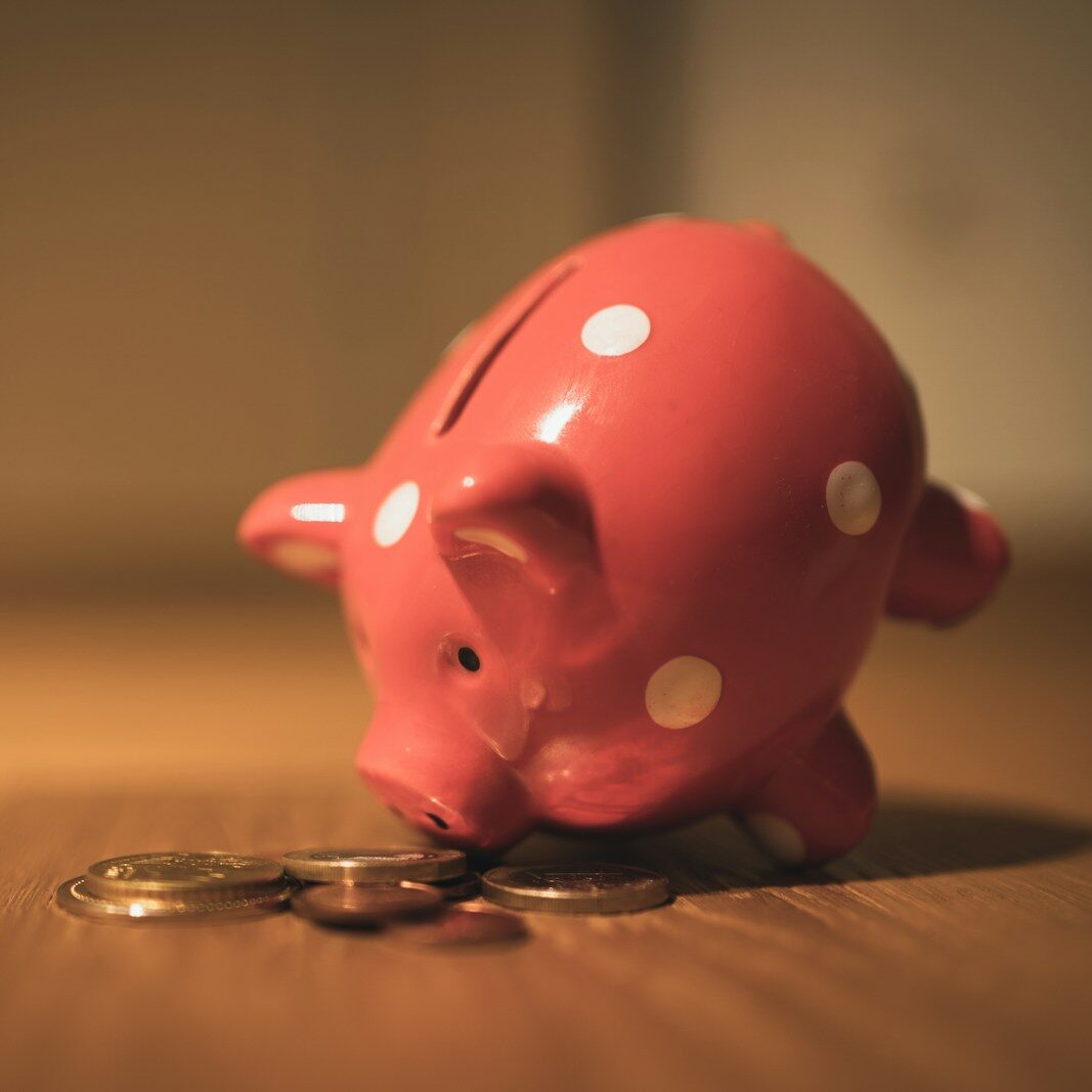 pink pig coin bank on brown wooden table